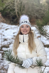 a lady in a white down coat and a white  knit hat